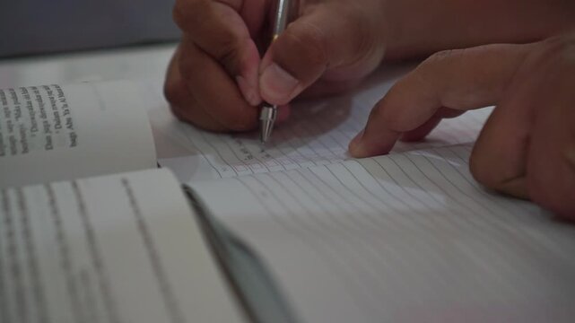 hand writing with a pen in a lined notebook. Education footage showing handwriting, studying, and everyday note-taking activity.