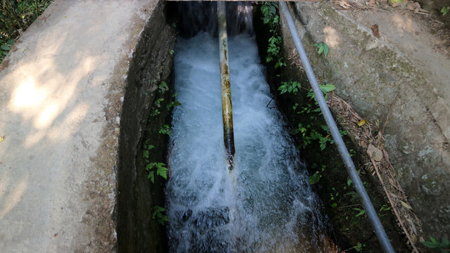 Fast flowing water rushing through concrete irrigation channel