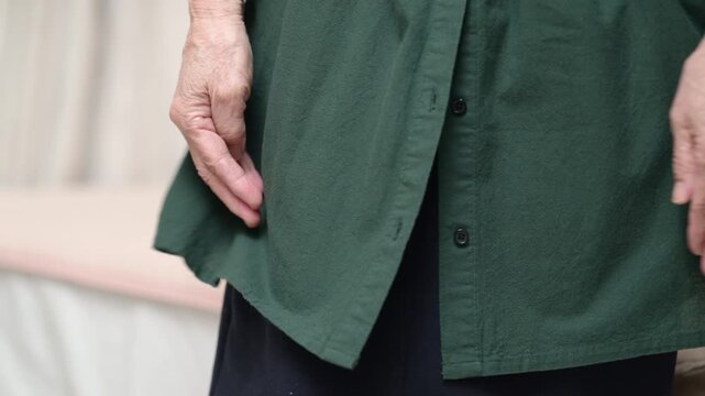 [スローモーション]膝の痛みを感じながらゆっくり立ち上がる高齢の日本人女性、膝痛、関節痛、加齢による身体の不調の動画
