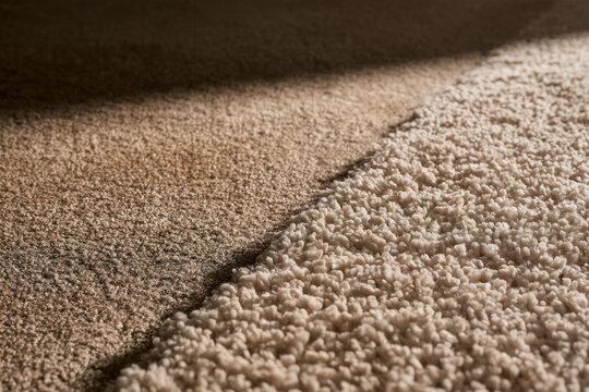 Beige carpet before and after cleaning, one side stained and the other fresh and fluffy