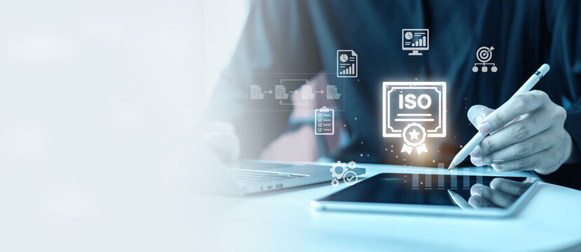 ISO certification quality management standard concept banner. Businessman with stylus pen on tablet with virtual ISO certificate badge, workflow and checklist icons with copy space.