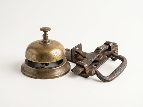 Antique metal doorbell mechanism and latch hardware on white