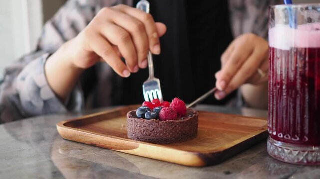 Enjoying dessert and drink at a cafe with a chocolate tart and fresh berries