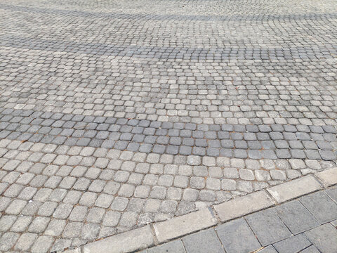 Weathered Surface of Gray Cobblestone Pavement with Curved Pattern