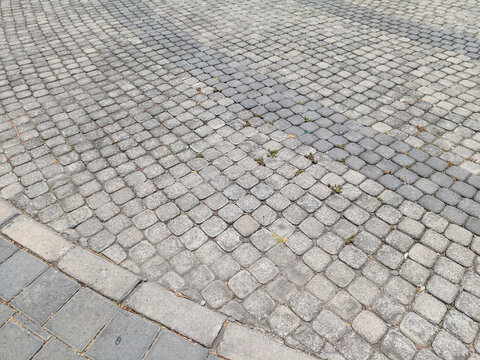 Weathered Surface of Gray Cobblestone Pavement with Curved Pattern