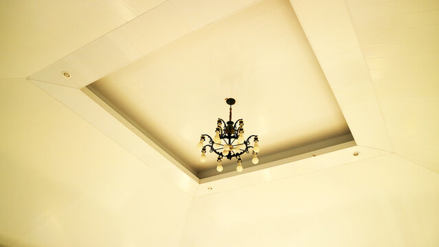 Vintage hanging chandelier light mounted on white ceiling room indoor
