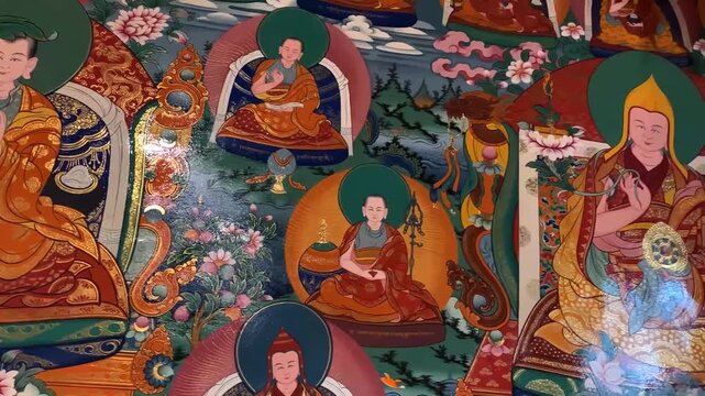 Traditional Tibetan thangka painting with multiple Buddhist monks in meditative poses, ornate floral motifs, and mountain landscapes