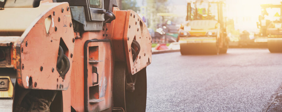 Heavy Road Rollers Compacting Fresh Asphalt on a City Street in Daylight