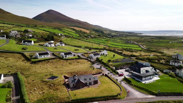 Flight over Inch Beach houses with mountains in the distance