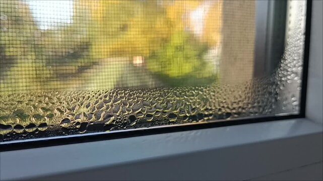 Water condensation drops on plastic window glass, humidity and temperature difference indoor problem horizontal.