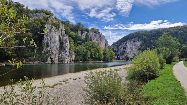 Steep limestone cliffs and gravel banks at the Danube Gorge in the Weltenburger Enge near Kelheim under a blue summer sky with wispy clouds, Altm&uuml;hltal Nature Park, Bavaria, Germany