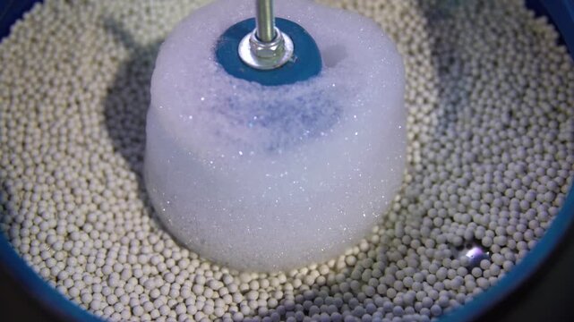 Industrial process of surface finishing using vibratory tumbler machine for metal parts polishing and deburring.