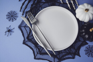 Halloween table setting with purple background and spider web decoration © reddish