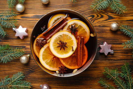 Hot spiced punch with oranges cinnamon and star anise on a wooden background