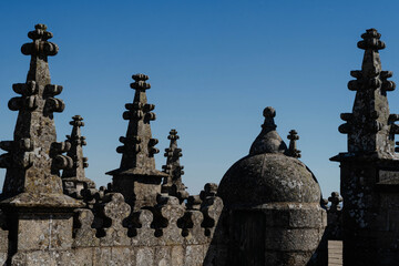 Gothic granite pinnacles and a domed stone turret on a cathedral rooftop in Guarda, Portugal under clear blue sky. Medieval church architecture for travel guides and heritage tourism. © Renata