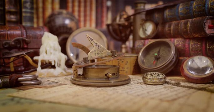 Cinematic pan across vintage navigation tools and antique books on old world map with melted candle.