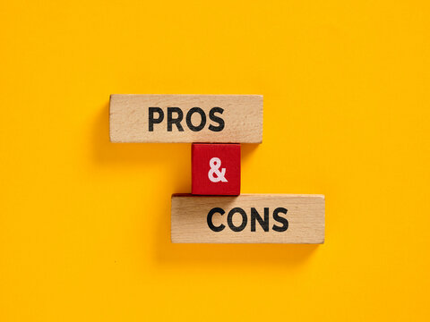 Wooden blocks showing pros and cons on yellow background