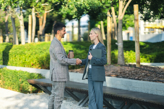 Business colleagues shaking hands in a park, establishing a new partnership