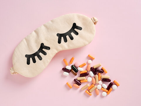 Sleep mask and pills representing sleep disorder, insomnia treatment and sleeping pill concept