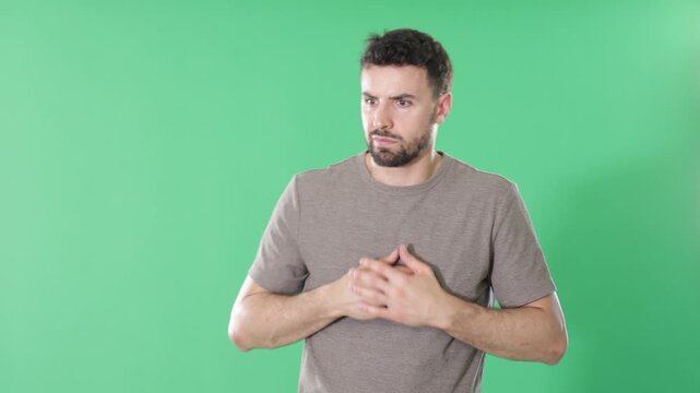 Adult man stands against green screen, touching head and looking puzzled, she forgot something important 