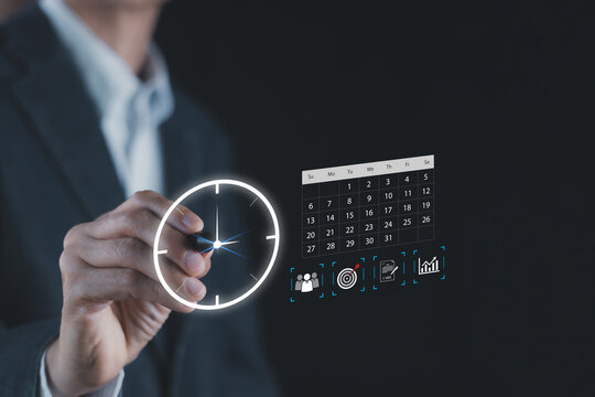 Close up of businessman hand pointing at digital clock and calendar hologram overlay. Concept of time management, project scheduling, business planning, deadline, and meeting organization.