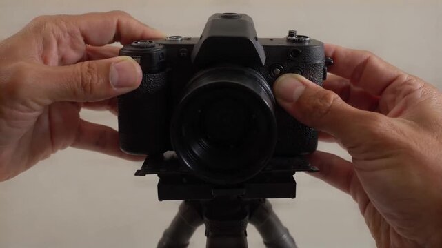 Hands mounting a camera onto a tripod plate