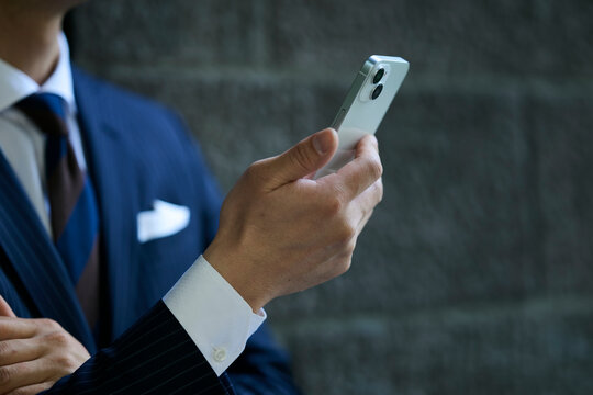スマートフォンを操作する男性ビジネスマンの手元