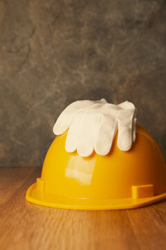 Hard hat and gloves on a wooden table.