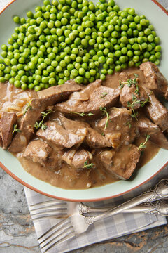 Saure Leber a traditional German beef liver dish from Baden closeup on the plate on the table. Vertical top view from above