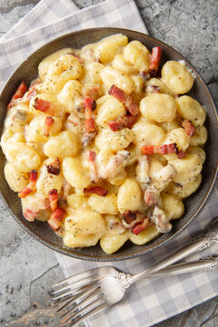 gnocchi carbonara a comforting twist on the classic pasta dish closeup on the plate on the table. Vertical top view from above