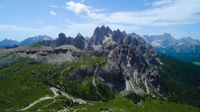 Aerial view of majestic jagged peaks of Tre Cime di Lavaredo mountain range in Italian Dolomites during sunny summer day.