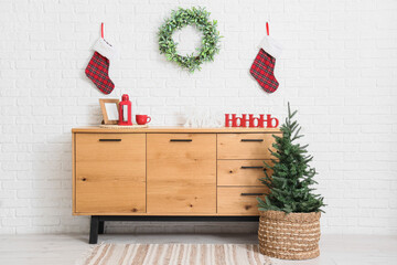 Fototapeta premium Interior of room with commode, Christmas tree and wreath
