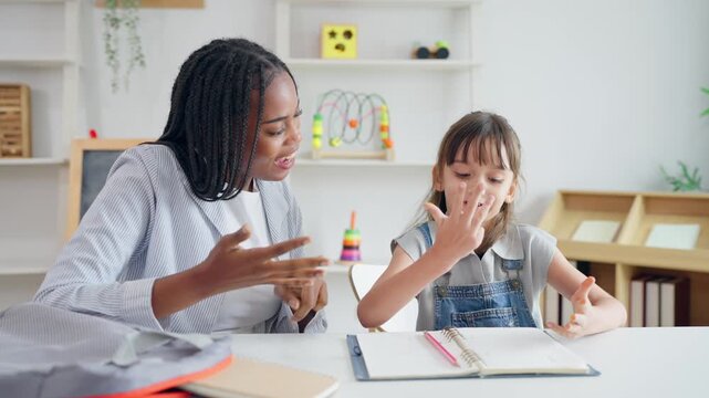 African woman tutor guide young child through learning activities on table. 