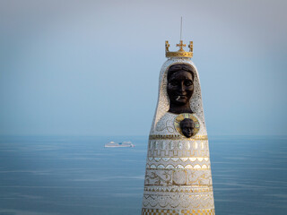 Close-up view of Our Lady of Loretto mosaic statue on Gaj hill with cruise ship in the background on Adriatic Sea during dusk, Primosten, Croatia © ventura