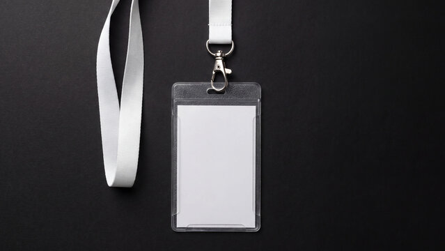 Blank identification card holder with white lanyard resting flat on a dark background