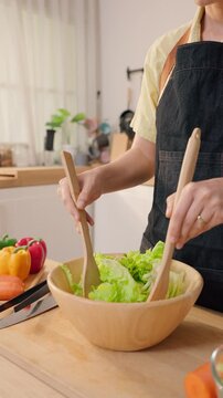Close up of young woman cooking healthy foods in cozy kitchen at home.