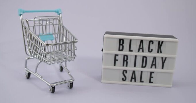 Miniature shopping cart next to a black friday sale lightbox sign