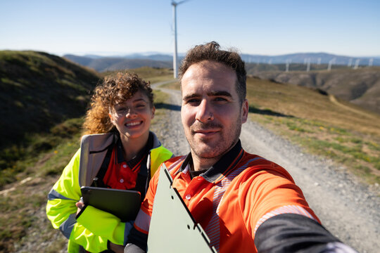 White people taking selfie at wind farm trail in Galicia, Spain