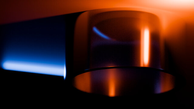 Blue and orange flames on metal gas burner in dark setting
