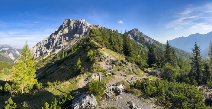 Scenic view of mountain peak Hochturm in Hochschwab region, Styria, Austria. Steep rocky cliffs covered in deciduous trees in vibrant autumn colors. Wanderlust Austrian Alps.