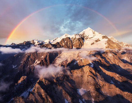 Rainbow over Mount Tetnuldi in the Caucasus Mountains landscape at sunset with glacier, Georgia - Europe