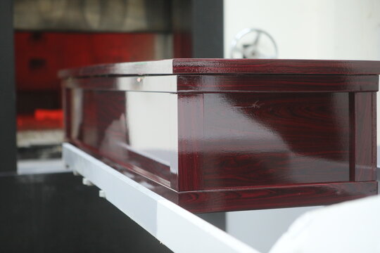 Wooden casket entering a crematorium furnace
