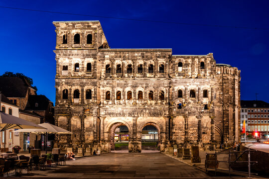 The illuminated Porta Nigra stands in Trier during blue hour