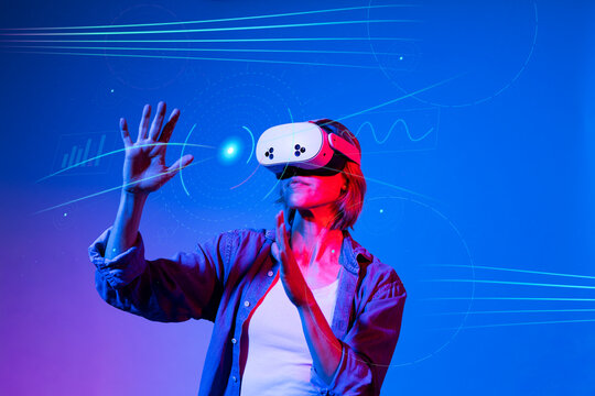 Woman interacts with virtual reality simulation in neon light