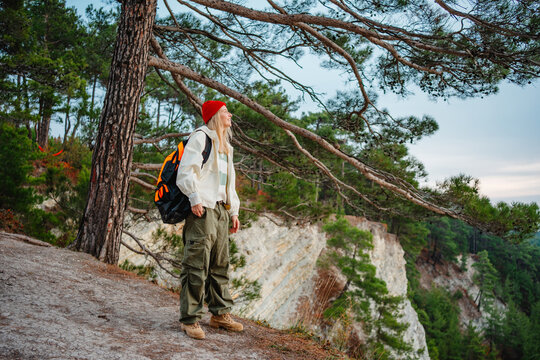 Woman with backpack explores coastal forest landscape