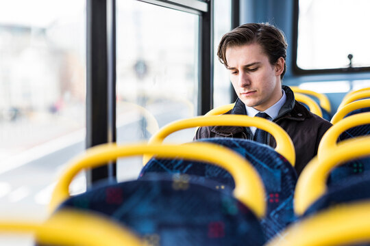 UK, London, portrait of serious businessman sitting in bus