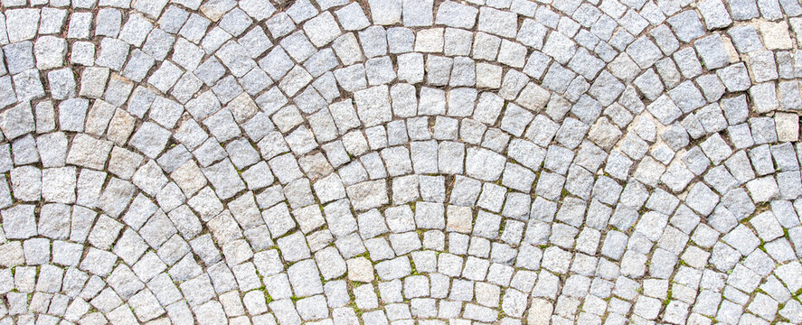 Classic fan shaped grey granite cobblestone pavement texture background