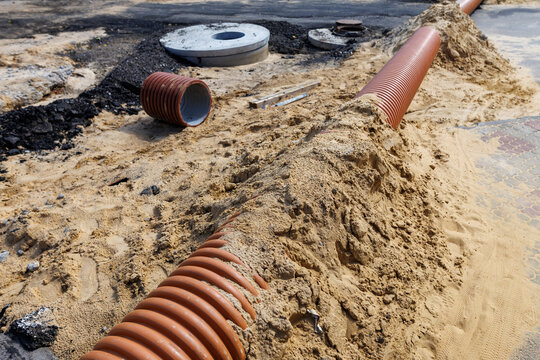 Exposed pipes lie in sandy ground