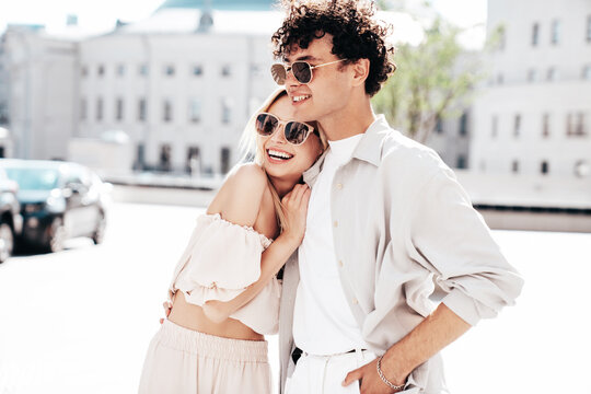 Young smiling beautiful woman and her handsome boyfriend in casual summer clothes. Happy cheerful family. Female having fun. Couple posing in the street background at sunny day. In sunglasses