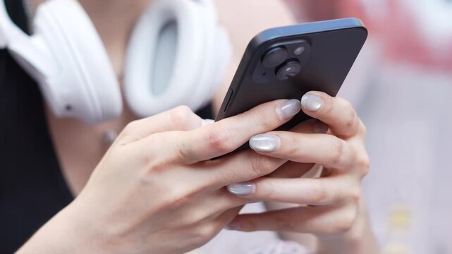 woman holds smart phone in her hands and scrolls through the news feed. Close up of hand uses mobile. point finger on screen, texting text message.